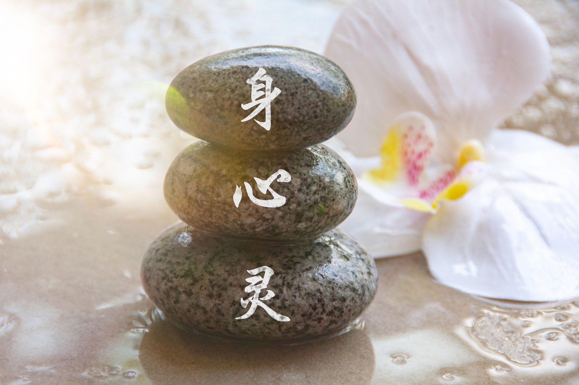 Black Zen stones with body, mind and spirit in Chinese character with shining light background