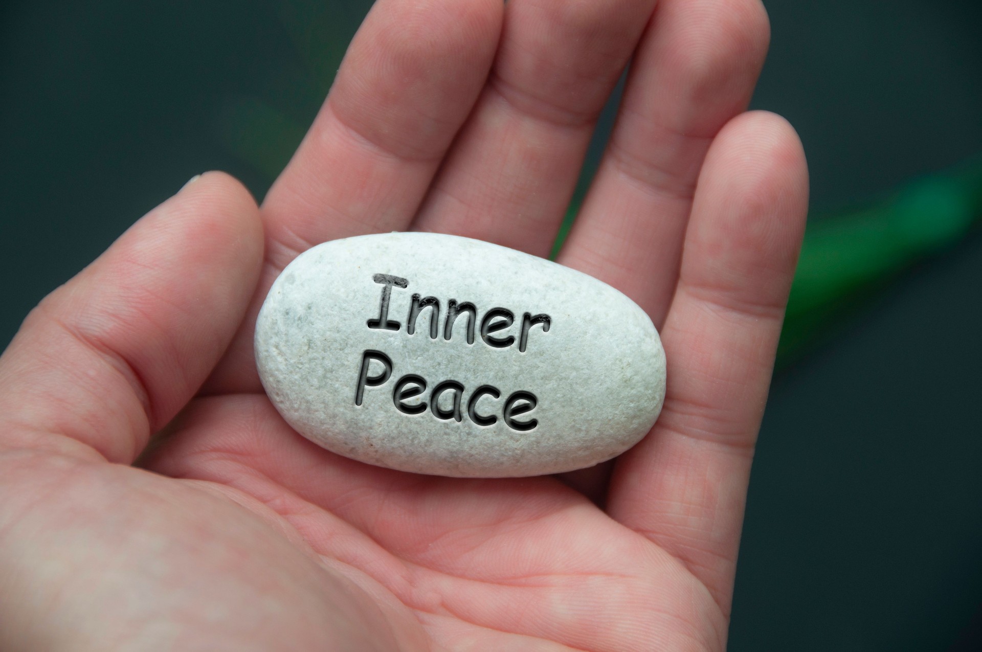 Inner peace text engraved on zen stones with hand background. Inner peace concept